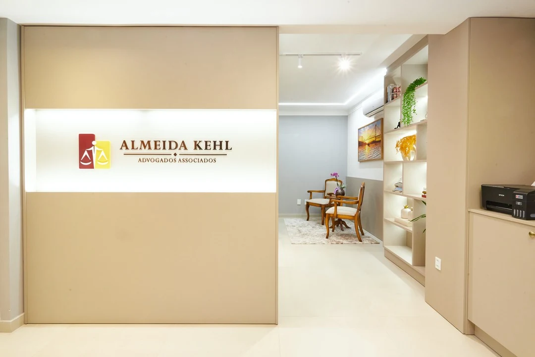 Interior do escritório Almeida Kehl, com o letreiro da marca e a área de recepção ao fundo